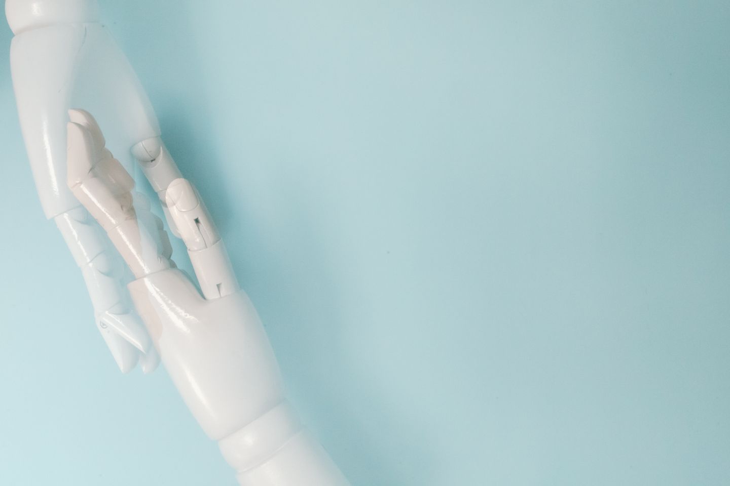 Deux mains robotiques sur fond bleu, illustration de la robotique et de l’intelligence artificielle